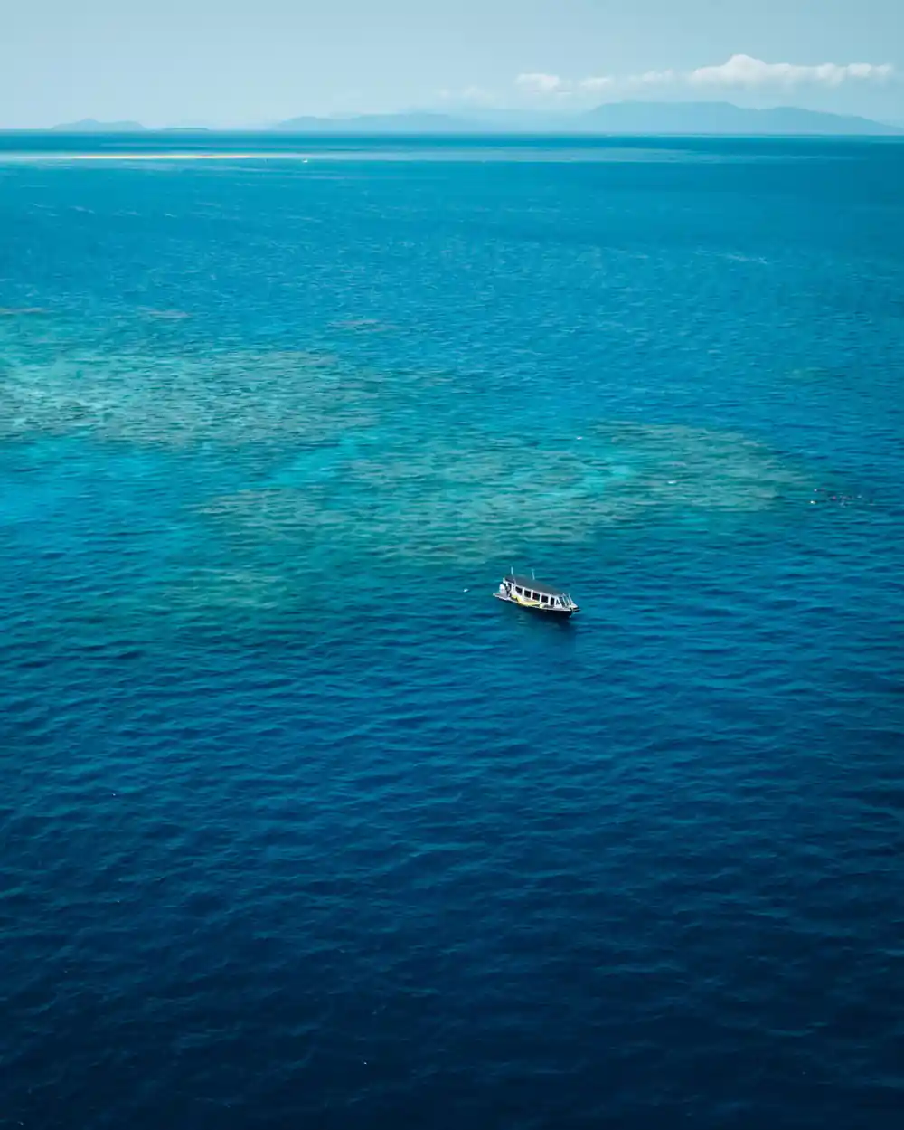Deep blue water beyond the reef edge with the boat moored
